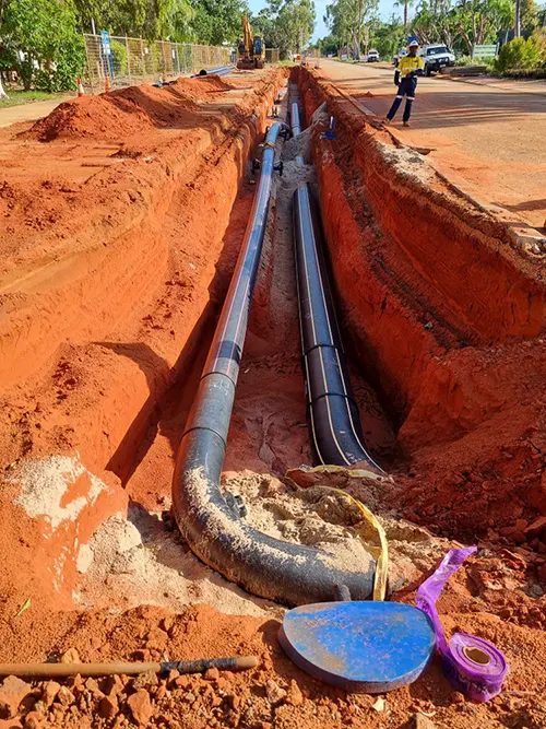 An open trench in Broome with HDPE pipe being layed