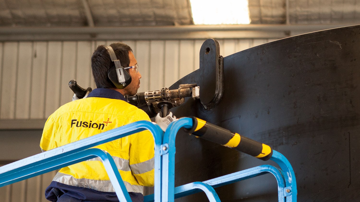 image of a Fusion employee extrusion welding a lifting lug into a PE fabricated tank.